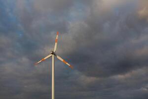 Wind turbine on the background of the blue sky. Clean renewable energy. Electric power production. photo