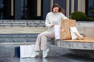 Beautiful young woman with shopping bags in the city. Shopping concept. photo