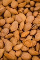 Almond nuts in a basket on a wooden background. photo