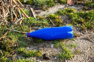 Plastic bottle on the shore of the lake. Environmental pollution. Plastic waste on the beach. photo