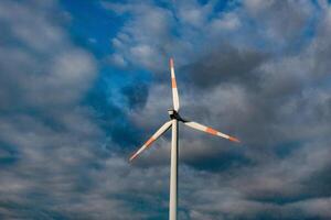 Wind turbine on the background of the blue sky. Clean renewable energy. Electric power production. photo