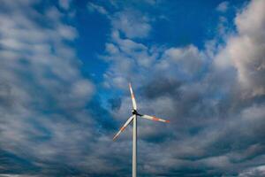 Wind turbine on the background of the blue sky. Clean renewable energy. Electric power production. photo