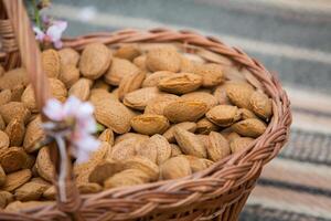 Almond nuts in a basket on a wooden background. photo