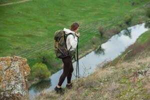 Young woman with backpack hiking in the mountains. Hiking concept. Trekking cliffs. Travel, traveler. photo