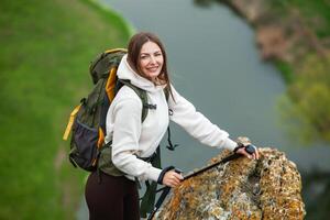 joven mujer con mochila excursionismo en el montañas. excursionismo concepto. trekking acantilados viajar, viajero. foto
