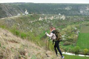 joven mujer con mochila excursionismo en el montañas. excursionismo concepto. trekking acantilados viajar, viajero. foto