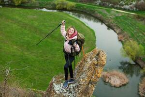 Young woman with backpack hiking in the mountains. Hiking concept. Trekking cliffs. Travel, traveler. photo