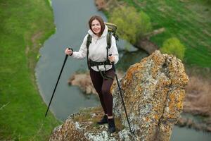 Young woman with backpack hiking in the mountains. Hiking concept. Trekking cliffs. Travel, traveler. photo