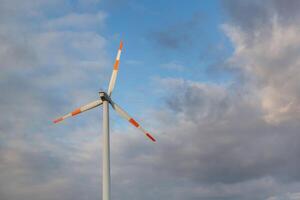 Wind turbine on the background of the blue sky. Clean renewable energy. Electric power production. photo