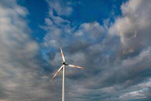 Wind turbine on the background of the blue sky. Clean renewable energy. Electric power production. photo