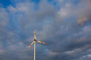 Wind turbine on the background of the blue sky. Clean renewable energy. Electric power production. photo