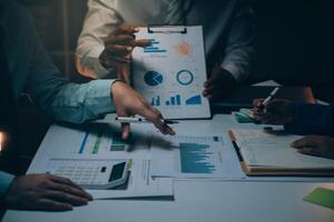 Business team meeting present, investor colleagues consultation and conference new strategy plan business and market growth on financial document graph report, Meeting and Talking. photo