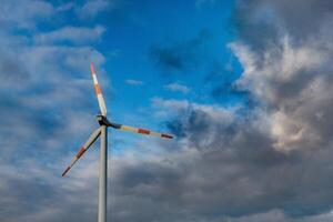 Wind turbine on the background of the blue sky. Clean renewable energy. Electric power production. photo