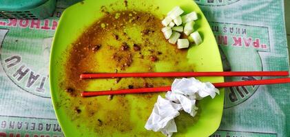 Top view of a photo of the plate after eating, you can see several dirty tissue sheets and a pair of eating used chopsticks.