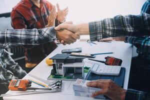 arquitecto y ingeniero construcción trabajadores sacudida manos mientras trabajando para trabajo en equipo y cooperación concepto después terminar un acuerdo en el oficina construcción sitio, éxito colaboración concepto foto