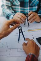 engineer people meeting working and pointing at a drawings in office for discussing. Engineering tools and construction concept. photo