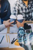 imagen de ingeniero reunión para arquitectónico proyecto. trabajando con compañero y Ingenieria herramientas en lugar de trabajo Clásico tono. foto