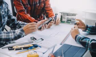 engineer people meeting working and pointing at a drawings in office for discussing. Engineering tools and construction concept. photo