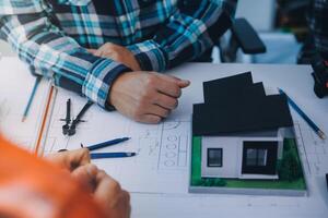 engineer people meeting working and pointing at a drawings in office for discussing. Engineering tools and construction concept. photo