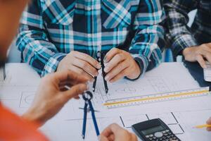 ingeniero personas reunión trabajando y señalando a un dibujos en oficina para que se discute. Ingenieria herramientas y construcción concepto. foto