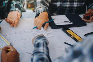 engineer people meeting working and pointing at a drawings in office for discussing. Engineering tools and construction concept. photo