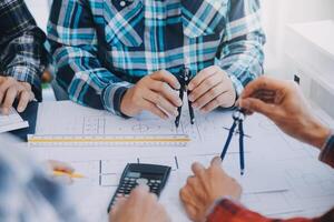 engineer people meeting working and pointing at a drawings in office for discussing. Engineering tools and construction concept. photo