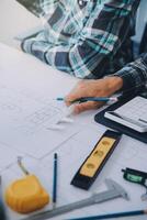 engineer people meeting working and pointing at a drawings in office for discussing. Engineering tools and construction concept. photo