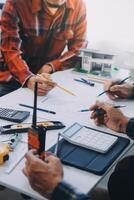 engineer people meeting working and pointing at a drawings in office for discussing. Engineering tools and construction concept. photo