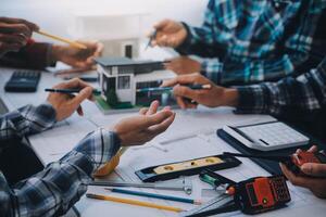 engineer people meeting working and pointing at a drawings in office for discussing. Engineering tools and construction concept. photo