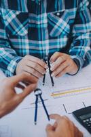 ingeniero personas reunión trabajando y señalando a un dibujos en oficina para que se discute. Ingenieria herramientas y construcción concepto. foto