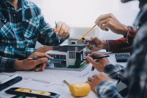 engineer people meeting working and pointing at a drawings in office for discussing. Engineering tools and construction concept. photo