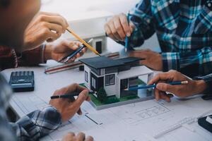 engineer people meeting working and pointing at a drawings in office for discussing. Engineering tools and construction concept. photo