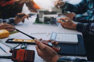 engineer people meeting working and pointing at a drawings in office for discussing. Engineering tools and construction concept. photo