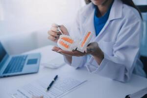 los dentistas están discutiendo problemas dentales al informar la imagen de rayos X en la pantalla del portátil a los pacientes. foto