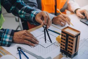 imagen de ingeniero reunión para arquitectónico proyecto. trabajando con compañero y Ingenieria herramientas en lugar de trabajo Clásico tono. foto