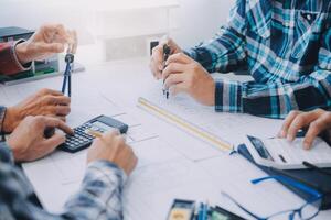 ingeniero personas reunión trabajando y señalando a un dibujos en oficina para que se discute. Ingenieria herramientas y construcción concepto. foto