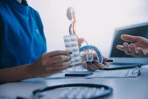 Doctor uses anatomical model to explain male urinary system. Model labeled with parts, doctor points and explains how they work together for urinary function, ensuring patient comprehension. photo