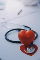 Doctor explaining heart to elderly patient. Doctor explaining the heart model. Doctors pen point to a model of the heart photo