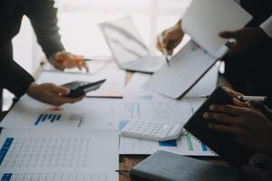 negocio equipo trabajando con nuevo puesta en marcha proyecto plan y discusión información para financiero estrategia con ordenador portátil y digital tableta en un moderno negocio salón. foto