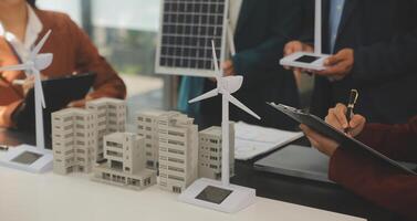 Close-up at tablet, Engineers pointing at tablet with their hands. To jointly design the use of renewable energy with wind and solar energy. Concept of using renewable energy. photo