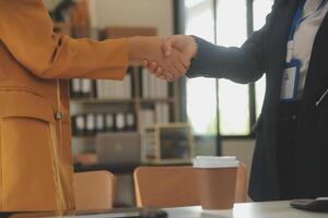 Real estate broker agent and customer shaking hands after signing contract documents for realty purchase, Bank employees congratulate, Concept mortgage loan approval. photo