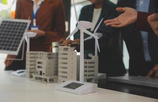 Close-up at tablet, Engineers pointing at tablet with their hands. To jointly design the use of renewable energy with wind and solar energy. Concept of using renewable energy. photo