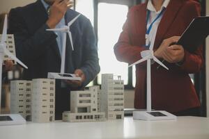 de cerca a tableta, ingenieros señalando a tableta con su manos. a conjuntamente diseño el utilizar de renovable energía con viento y solar energía. concepto de utilizando renovable energía. foto