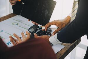 negocio equipo trabajando con nuevo puesta en marcha proyecto plan y discusión información para financiero estrategia con ordenador portátil y digital tableta en un moderno negocio salón. foto