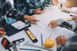 engineer people meeting working and pointing at a drawings in office for discussing. Engineering tools and construction concept. photo