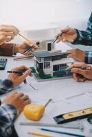 engineer people meeting working and pointing at a drawings in office for discussing. Engineering tools and construction concept. photo