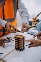 imagen de ingeniero reunión para arquitectónico proyecto. trabajando con compañero y Ingenieria herramientas en lugar de trabajo Clásico tono. foto