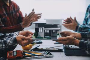 engineer people meeting working and pointing at a drawings in office for discussing. Engineering tools and construction concept. photo