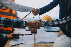 imagen de ingeniero reunión para arquitectónico proyecto. trabajando con compañero y Ingenieria herramientas en lugar de trabajo Clásico tono. foto