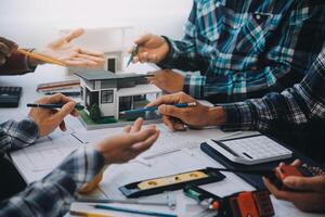 engineer people meeting working and pointing at a drawings in office for discussing. Engineering tools and construction concept. photo